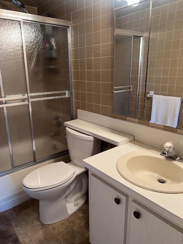 full bathroom with vanity, tile patterned floors, shower / bath combination with glass door, and toilet