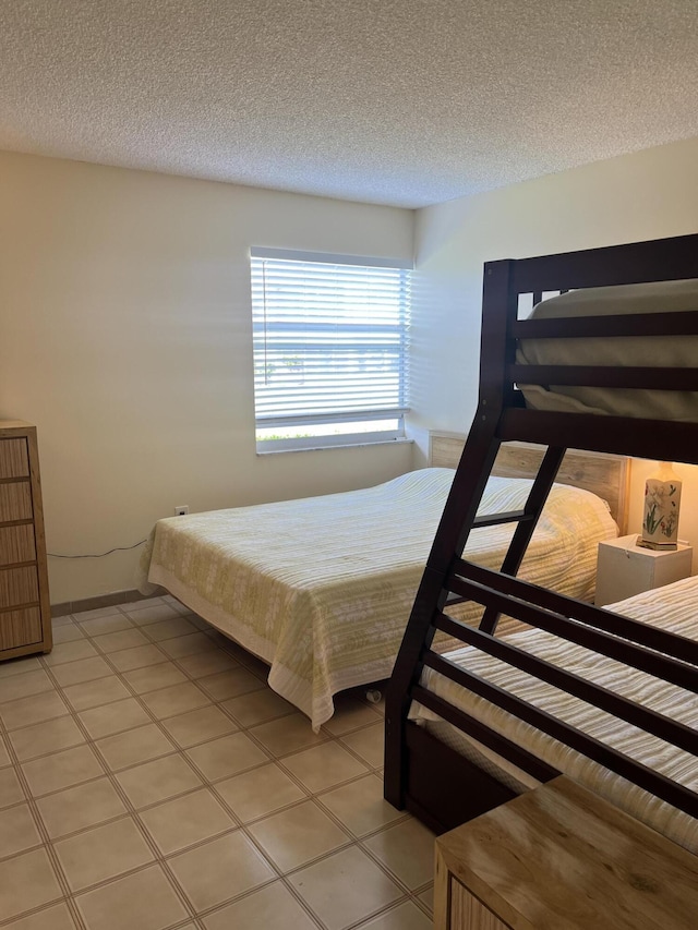 tiled bedroom featuring a textured ceiling