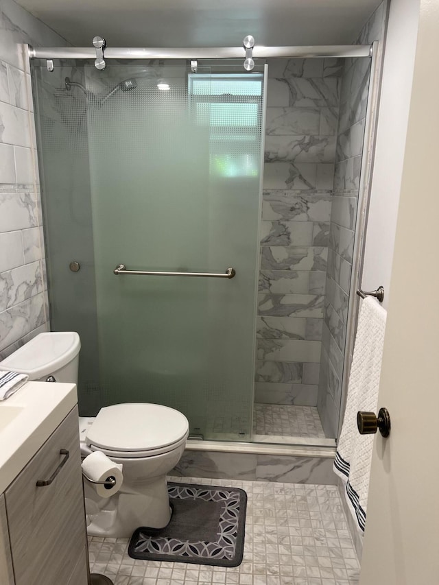 bathroom with vanity, toilet, and a shower with shower door