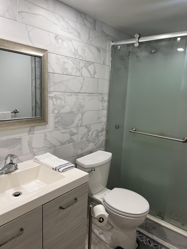 bathroom with tasteful backsplash, tile walls, vanity, toilet, and a shower with door