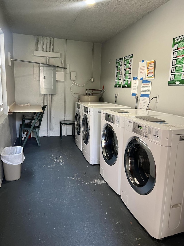 laundry area featuring a textured ceiling, electric panel, and independent washer and dryer