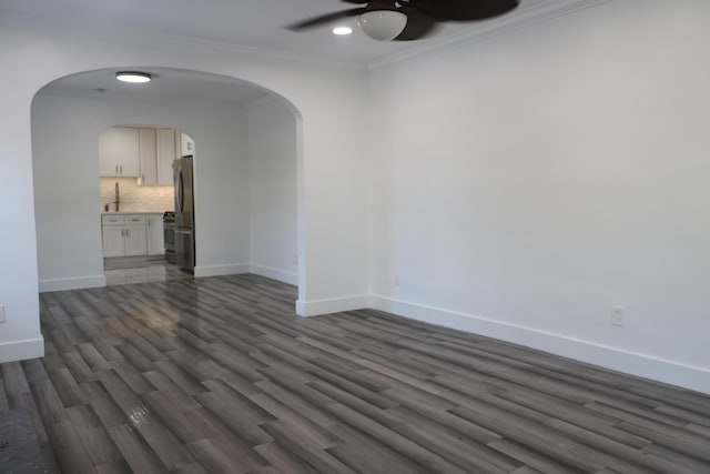 spare room with ornamental molding, ceiling fan, and dark hardwood / wood-style flooring