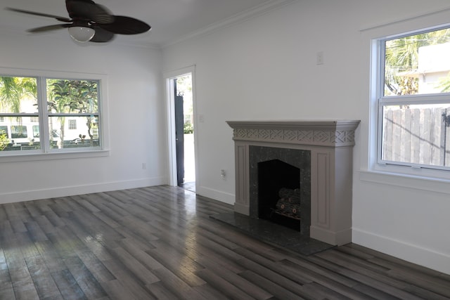 unfurnished living room featuring crown molding, a healthy amount of sunlight, dark wood-type flooring, and a fireplace