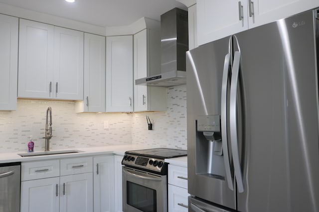 kitchen with white cabinetry, wall chimney range hood, and appliances with stainless steel finishes