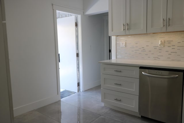 kitchen with tasteful backsplash, stainless steel dishwasher, light tile patterned flooring, and white cabinets