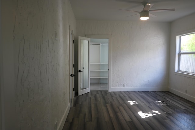 empty room with ceiling fan and dark hardwood / wood-style flooring