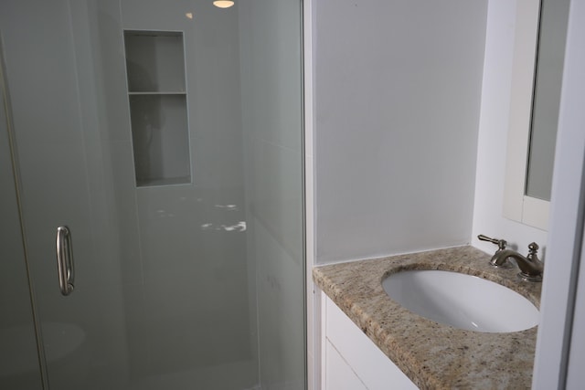 bathroom featuring vanity and a shower with shower door