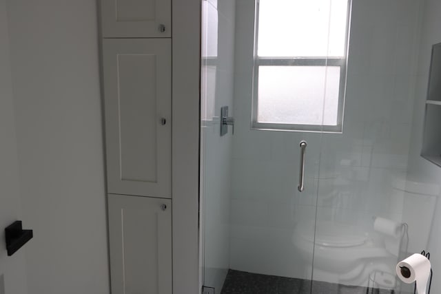 bathroom featuring walk in shower and toilet