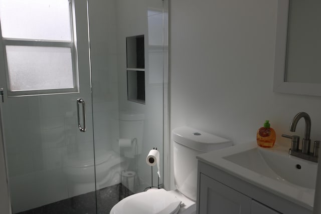 bathroom with walk in shower, vanity, and toilet