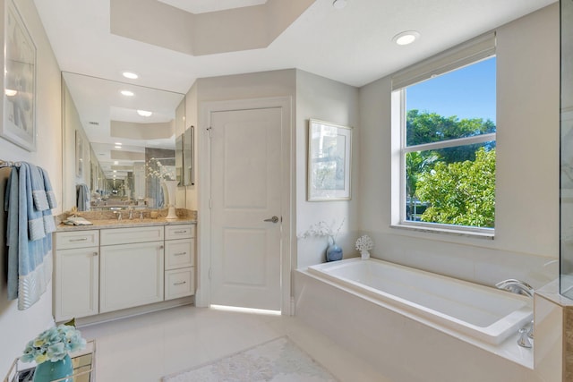 bathroom with vanity, a healthy amount of sunlight, tile patterned floors, and a bathtub