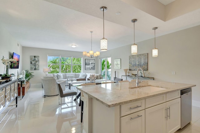 kitchen featuring sink, white cabinetry, light stone counters, hanging light fixtures, and stainless steel dishwasher