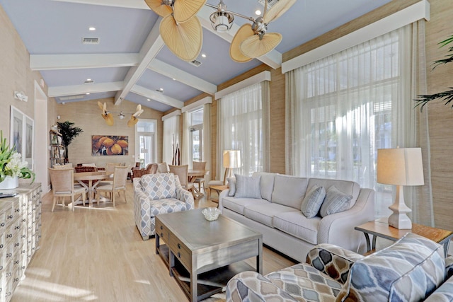 living room featuring vaulted ceiling with beams and light hardwood / wood-style flooring