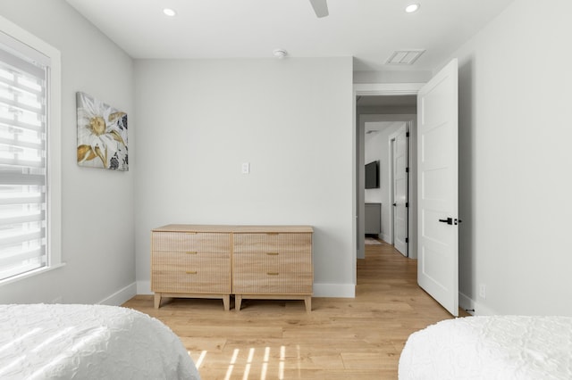 bedroom featuring ceiling fan, multiple windows, and light wood-type flooring