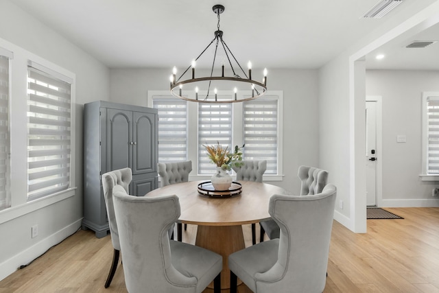 dining room with a notable chandelier and light hardwood / wood-style floors