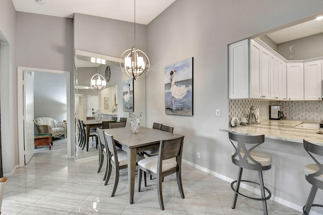 dining space featuring a chandelier and a high ceiling