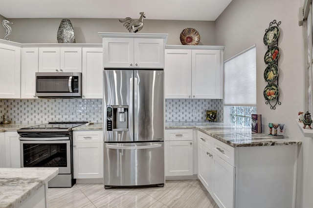 kitchen featuring white cabinetry, stainless steel appliances, light stone counters, and backsplash