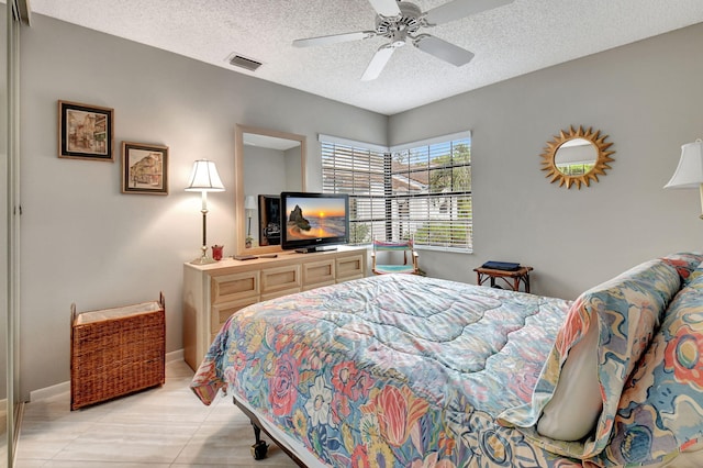 bedroom with light tile patterned floors, a textured ceiling, and ceiling fan