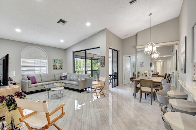 living room featuring high vaulted ceiling, a textured ceiling, and a notable chandelier