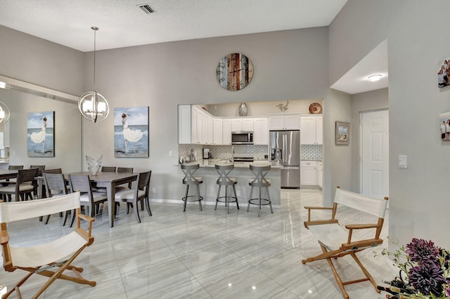 dining space with a high ceiling and an inviting chandelier