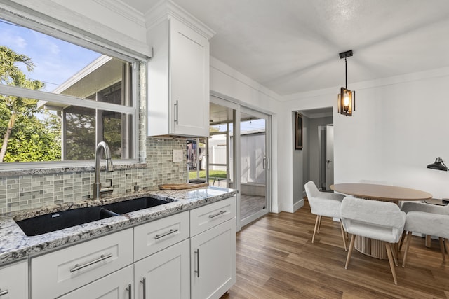 kitchen featuring light stone counters, dark hardwood / wood-style floors, sink, and white cabinets