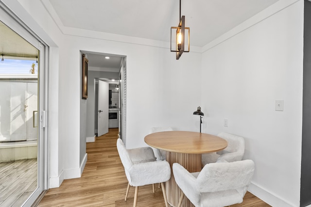 dining space with crown molding and wood-type flooring