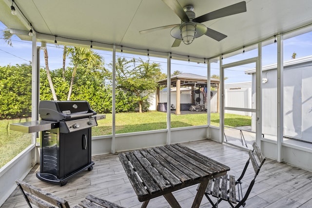 unfurnished sunroom with ceiling fan