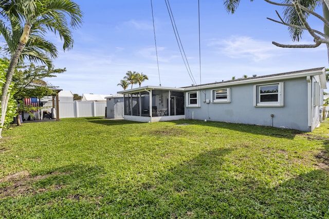 back of house featuring a yard and a sunroom