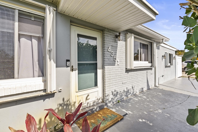 view of exterior entry with a patio