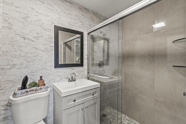 bathroom featuring vanity, toilet, tile walls, and walk in shower