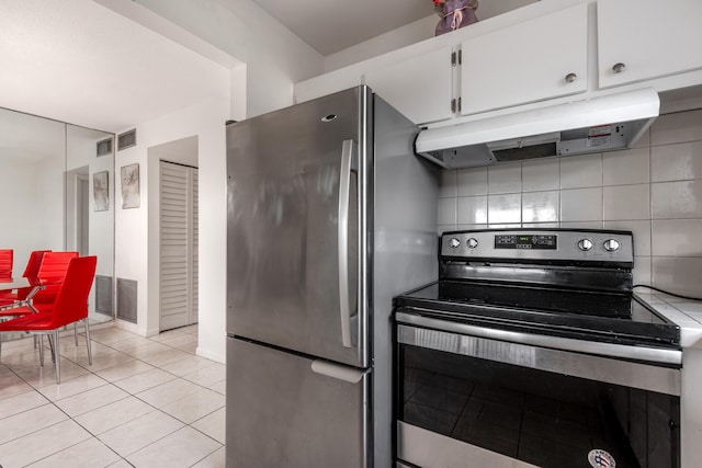 kitchen with backsplash, appliances with stainless steel finishes, light tile patterned floors, and white cabinets