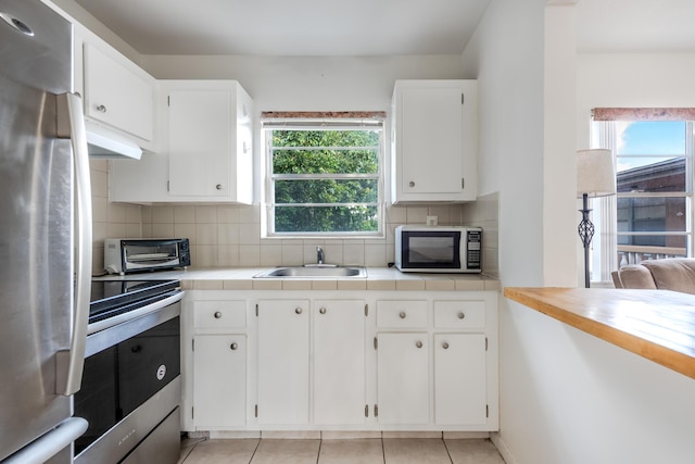 kitchen featuring white cabinetry, appliances with stainless steel finishes, sink, and backsplash