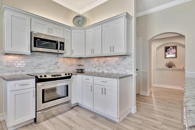 kitchen with light stone counters, white cabinets, and appliances with stainless steel finishes