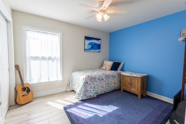 bedroom featuring a textured ceiling, ceiling fan, and light hardwood / wood-style flooring