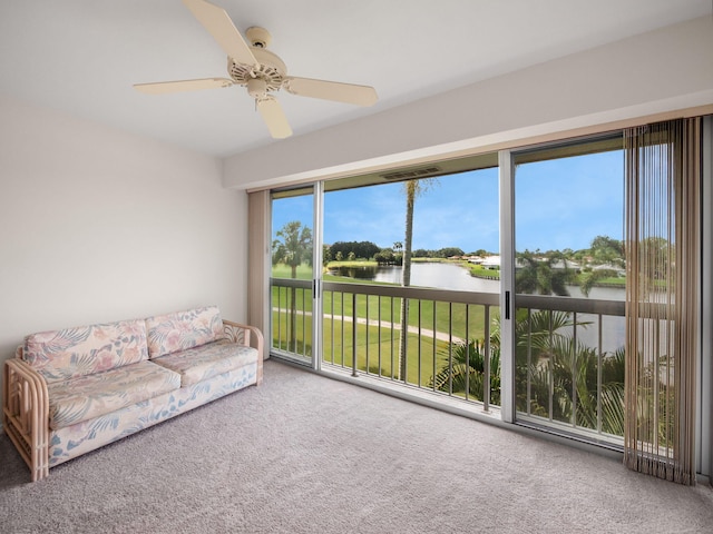 sunroom with a water view, ceiling fan, and a wealth of natural light