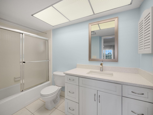 full bathroom featuring vanity, tile patterned flooring, shower / bath combination with glass door, and toilet