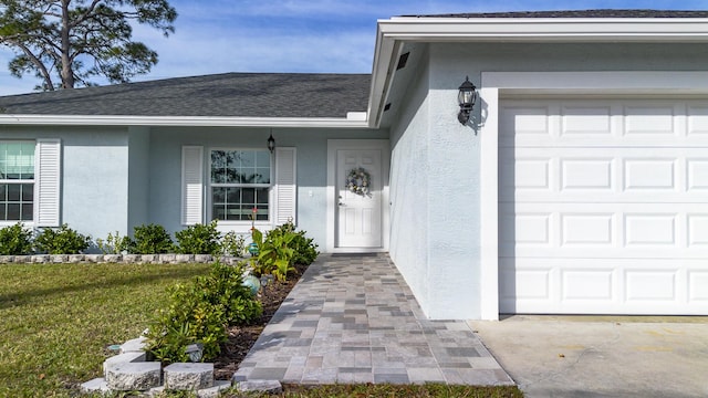 property entrance featuring a yard and a garage