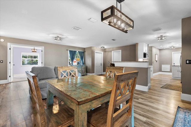 dining space with plenty of natural light and light wood-type flooring