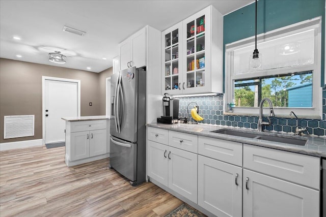 kitchen featuring decorative light fixtures, sink, white cabinets, light stone counters, and stainless steel refrigerator with ice dispenser