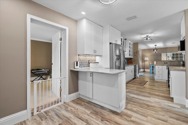 kitchen featuring stainless steel fridge with ice dispenser, tasteful backsplash, white cabinets, kitchen peninsula, and light wood-type flooring