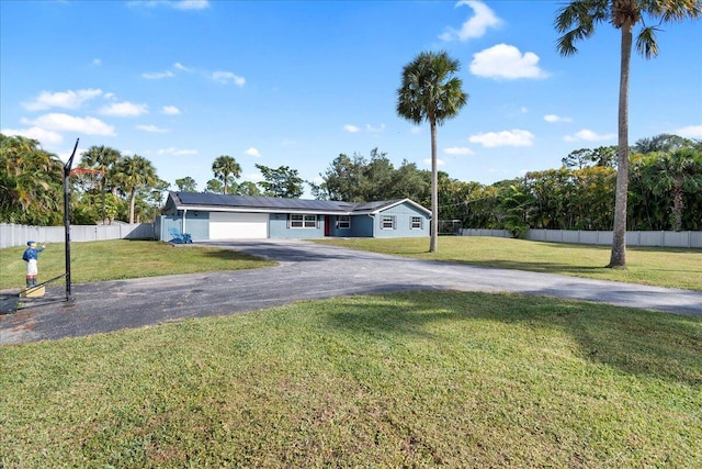 single story home with a garage, a front lawn, and solar panels