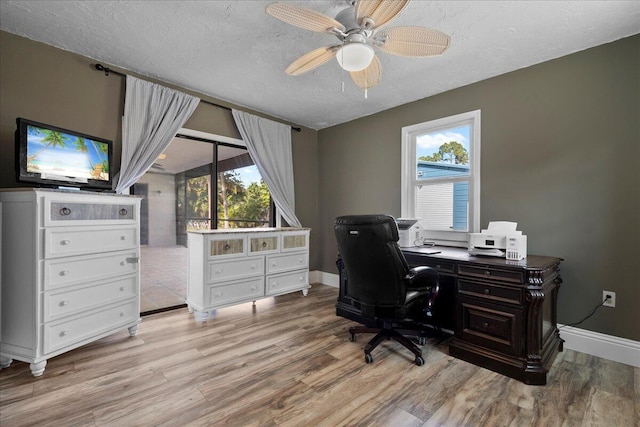 home office with ceiling fan, a textured ceiling, and light hardwood / wood-style flooring