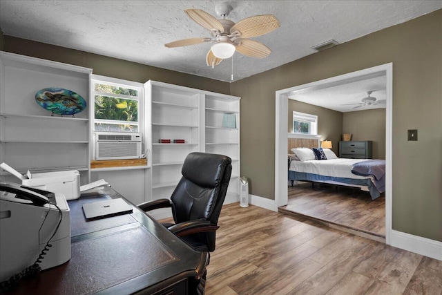 office space featuring hardwood / wood-style floors, a wealth of natural light, a textured ceiling, and ceiling fan