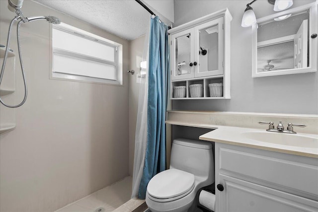 bathroom with vanity, toilet, a shower with shower curtain, and a textured ceiling