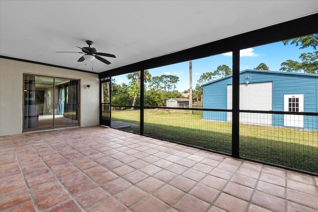 unfurnished sunroom featuring ceiling fan