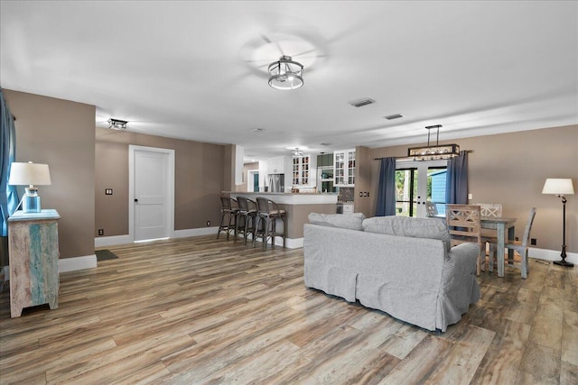 living room with light wood-type flooring and french doors