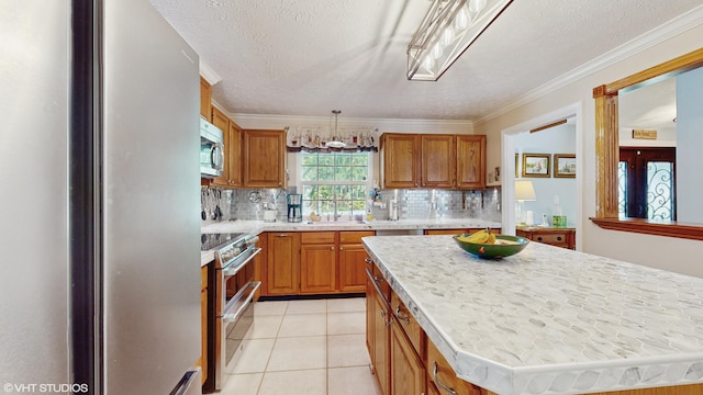 kitchen with a kitchen island, appliances with stainless steel finishes, sink, decorative backsplash, and light tile patterned floors