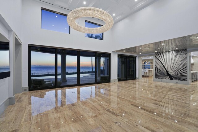 kitchen featuring a spacious island, glass insert cabinets, hanging light fixtures, custom exhaust hood, and light countertops