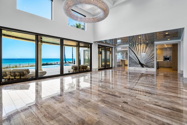 kitchen with a warming drawer, light countertops, custom range hood, appliances with stainless steel finishes, and an island with sink