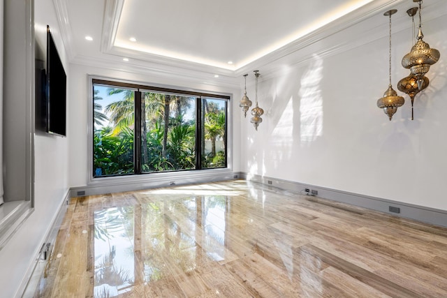 unfurnished room featuring ornamental molding, a tray ceiling, a water view, and a view of the beach