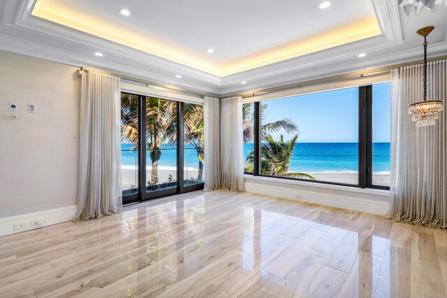 spare room with dark wood-style floors, a tray ceiling, ornamental molding, and recessed lighting